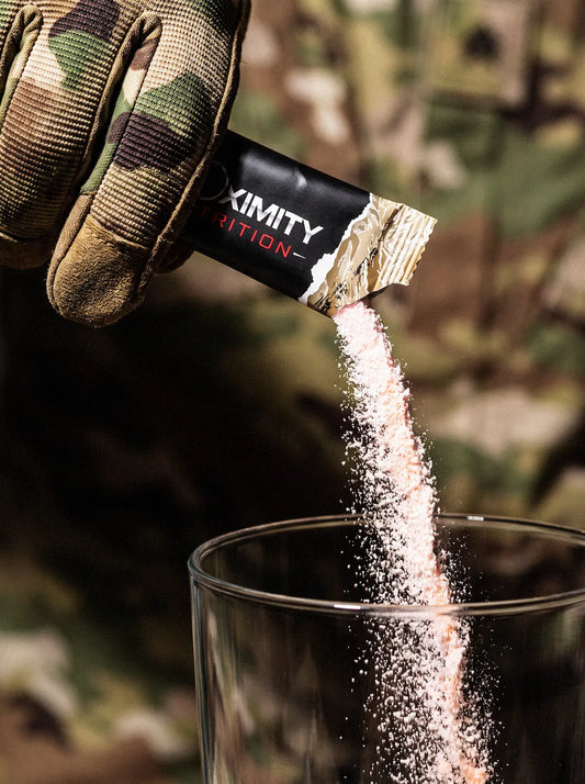 Gloved hand pouring powder from a T.O.T. stick into a clear glass.