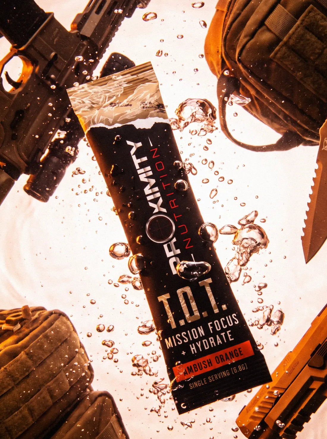 T.O.T. Ambush Orange stick pack surrounded by water droplets and tactical gear.