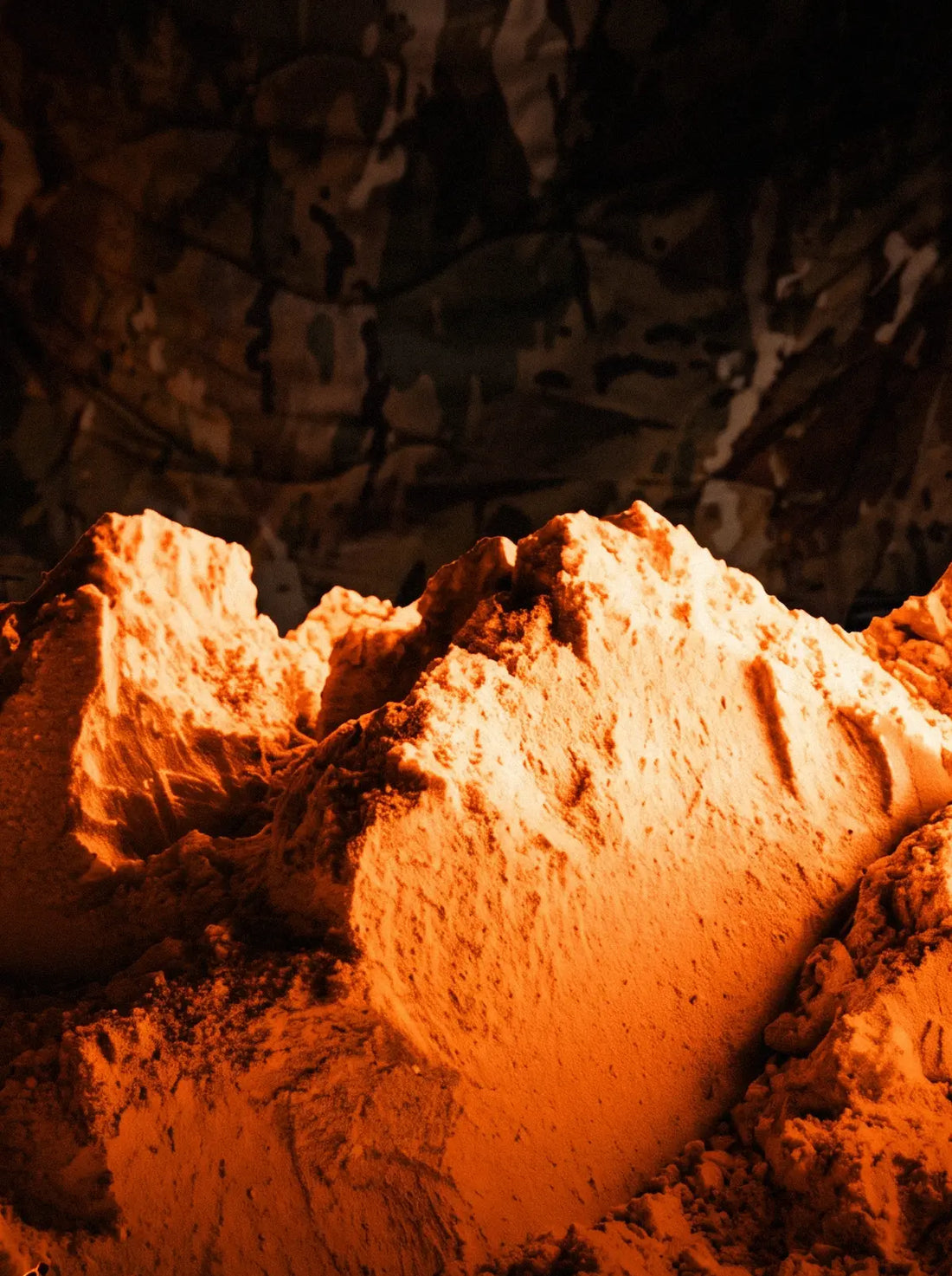 Close-up of orange powder mounds against a camouflage background.